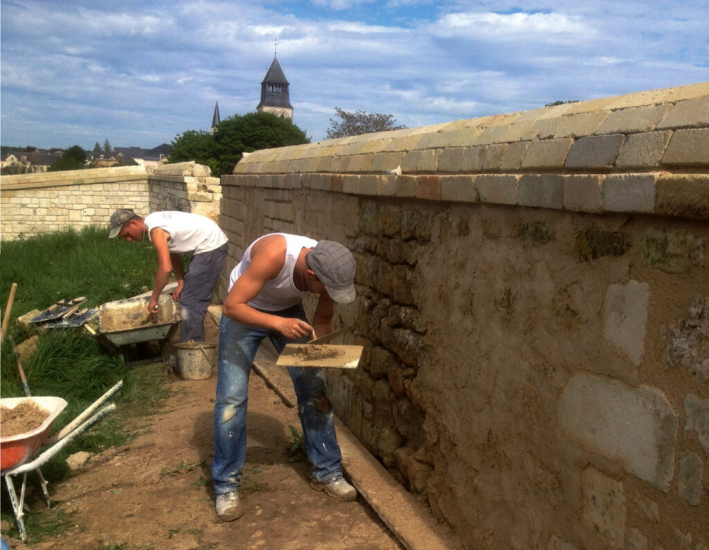 Refection d'un mur par l'équipe du Patrimoine bâti